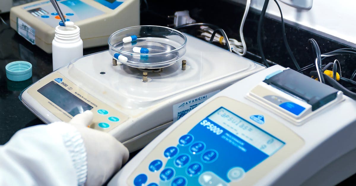 Manufacturing quality inspector using digital calipers to measure a machined part with SPC charts displayed on a nearby monitor