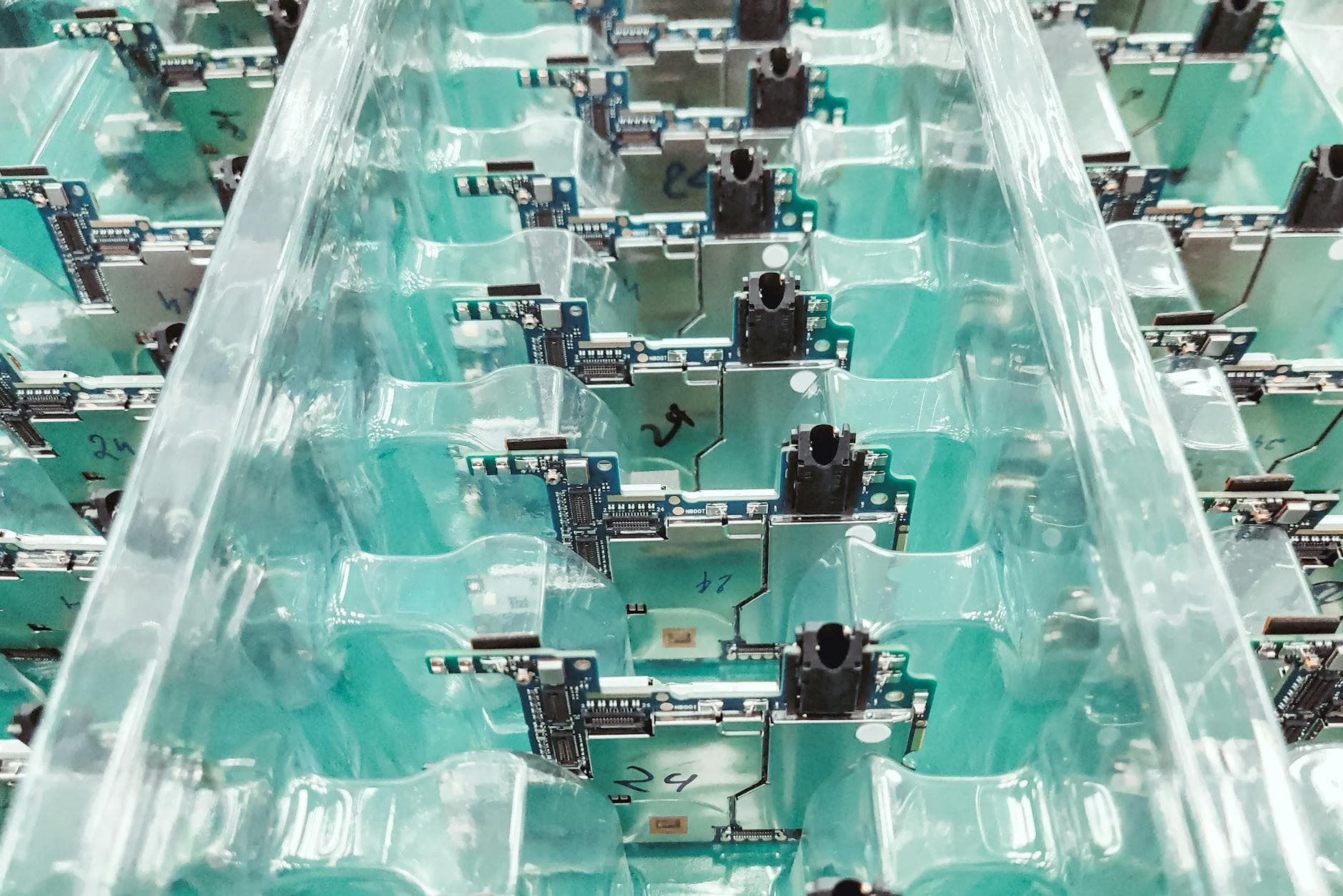 Assembly line worker organizing component kits in labeled bins on a manufacturing shop floor