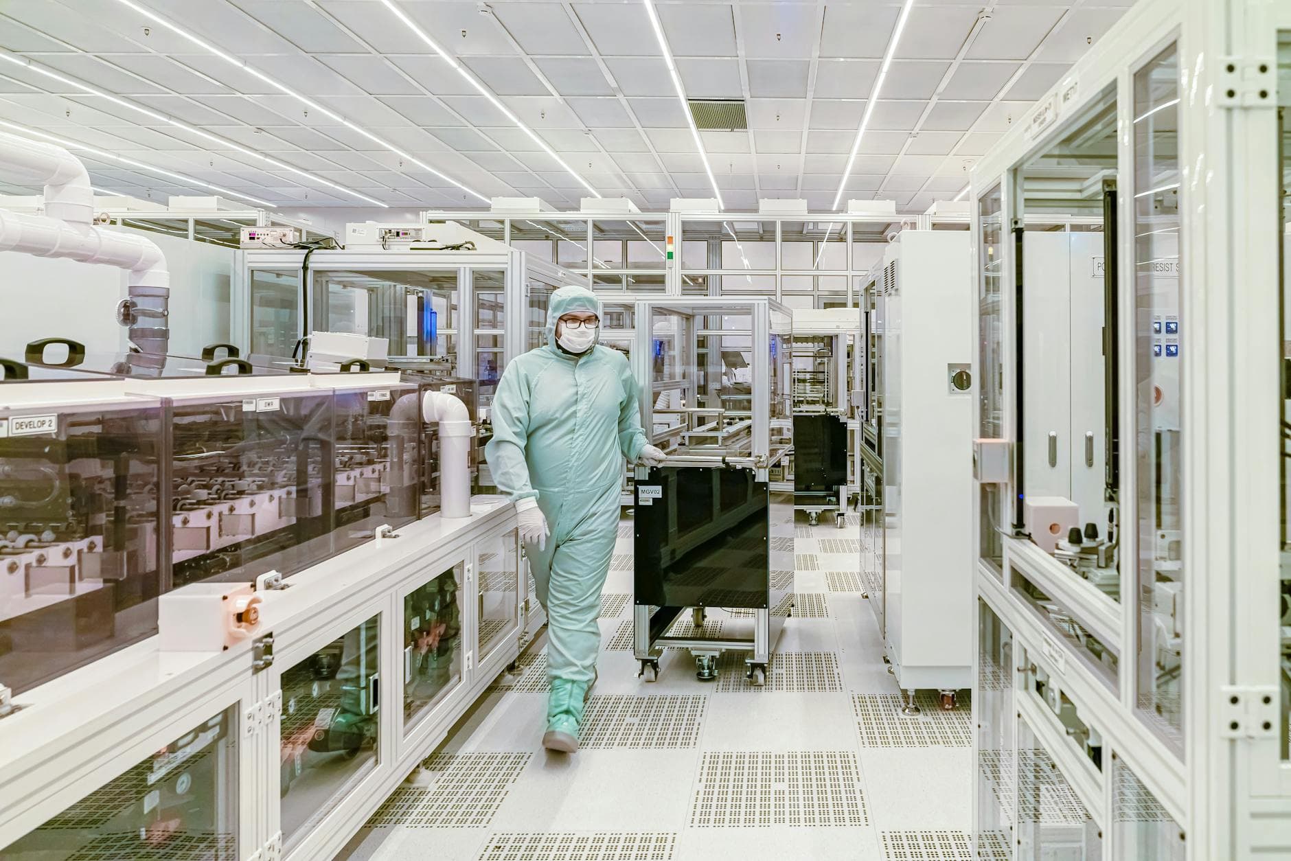 Manufacturing technician reviewing a standard operating procedure binder at a production workstation