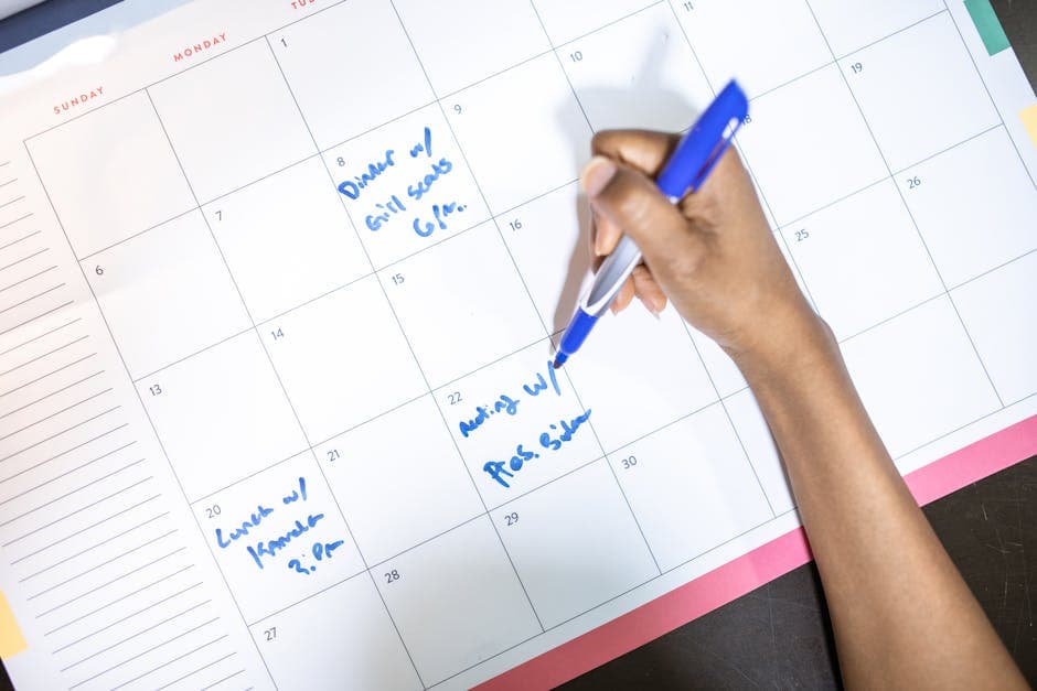Person reviewing a planning calendar, representing time fence zones in manufacturing MRP scheduling