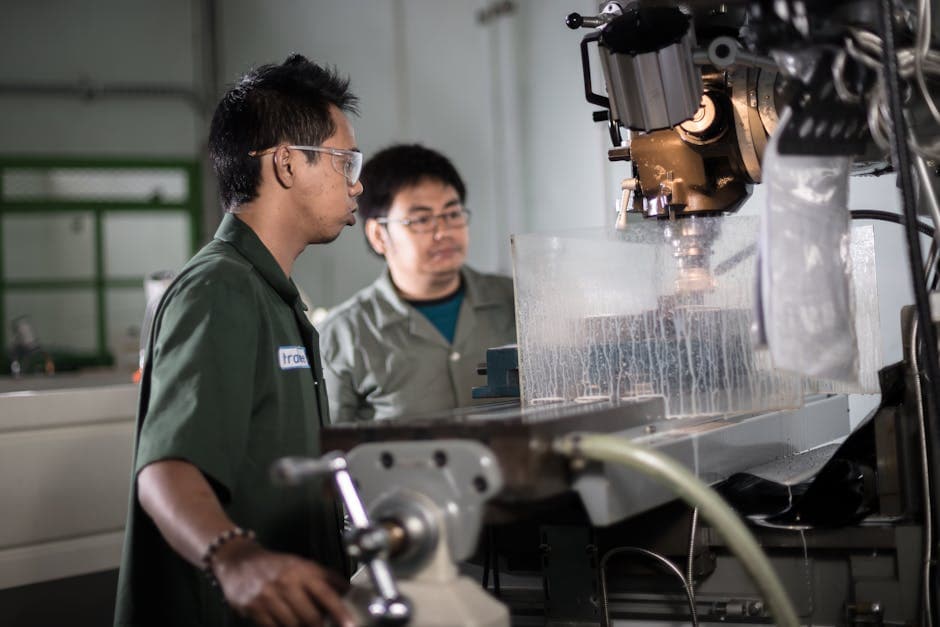 CNC machinist operator working on precision manufacturing equipment in job shop