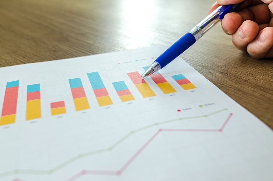 Manufacturing analyst reviewing supplier performance metrics and charts at a workstation